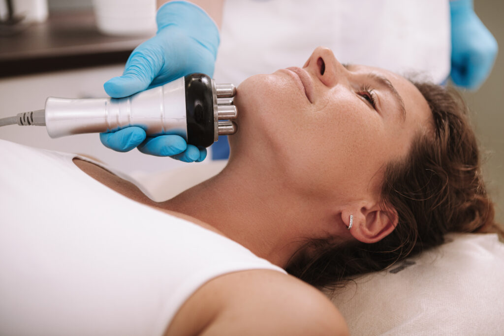 Cropped shot of a woman getting skin tightening treatment on her neck and chin. Beautician doing rf lifting facial procedure on female client