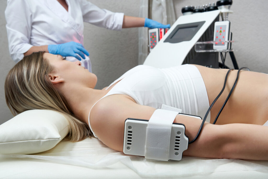 Beautiful woman getting electro stimulation therapy. Laser lipo equipment. Cosmetic fat reduce treatment