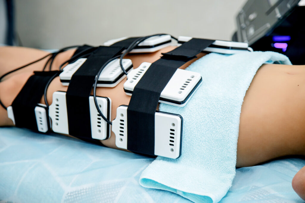 In a beauty salon, a girl performs a hardware procedure for weight loss laser lipolysis. Figure correction by hardware methods