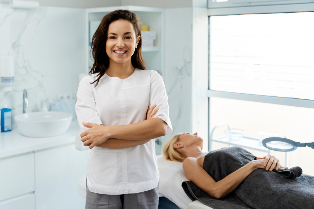 Portrait of cosmetologist in white lab coat looking at camera