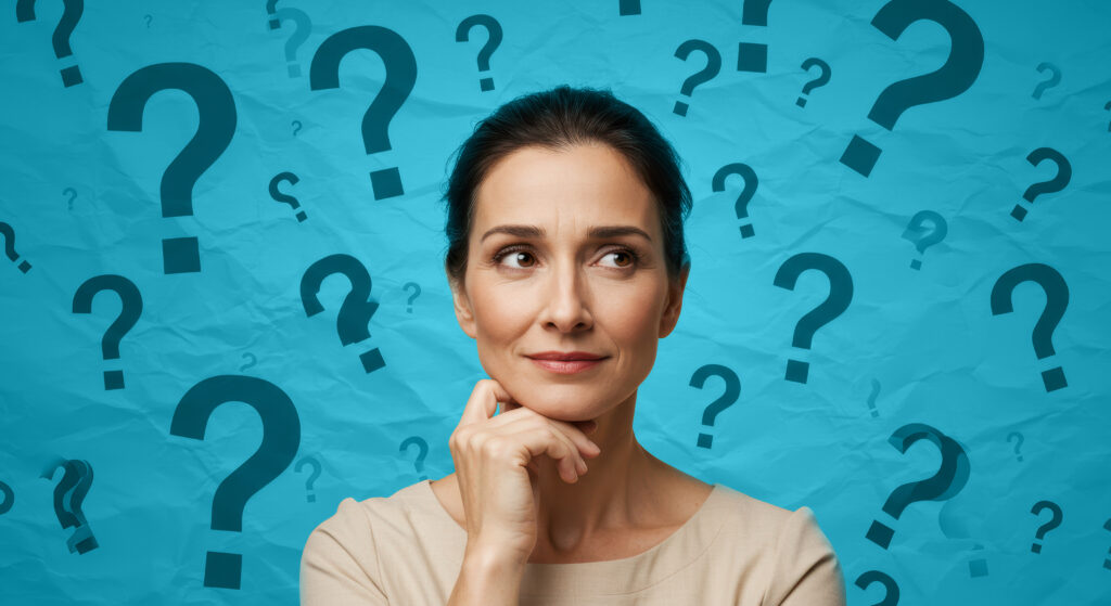 Thoughtful woman surrounded by question marks on orange crumpled